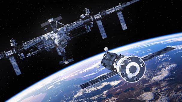 Spacestation in orbit above Earth-like planet with approaching spacecraft