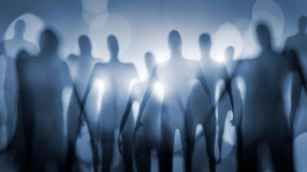 Blurred outline of group of aliens with bright light behind