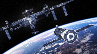 Spacestation in orbit above Earth-like planet with approaching spacecraft