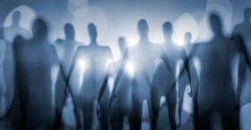 Burred outline of group of aliens with bright light behind